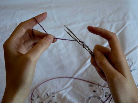 2. Hold both ends of the circular needles together and wrap yarn around the needles in a figure of eight pattern. 