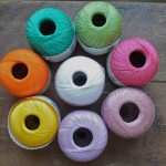 Rico Crochet Cotton. CW from Top – 009 Light Green, 005 Fushia, 016 Dusty Pink, 006 Lilac, 013 Yellow, 003 Orange, 008 Emerald. Centre- 001 White. Loop, London. www.loopknitlounge.com